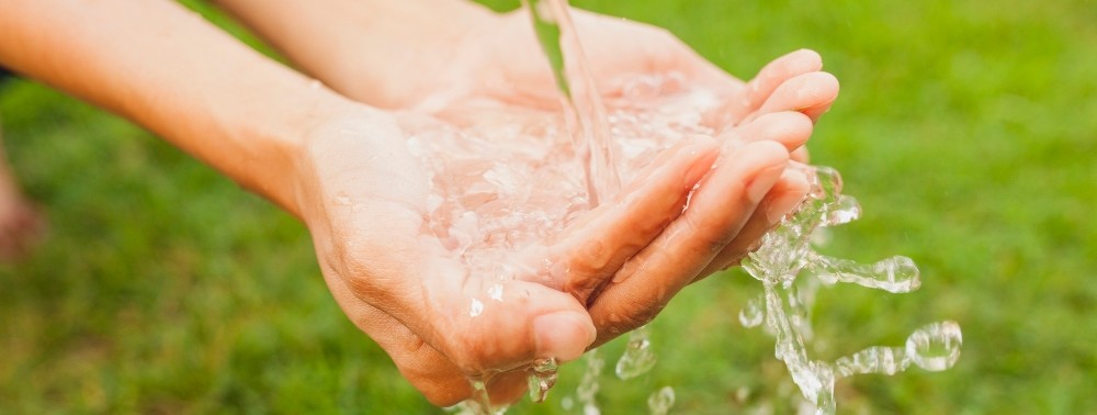 close-up-maos-corrente-agua