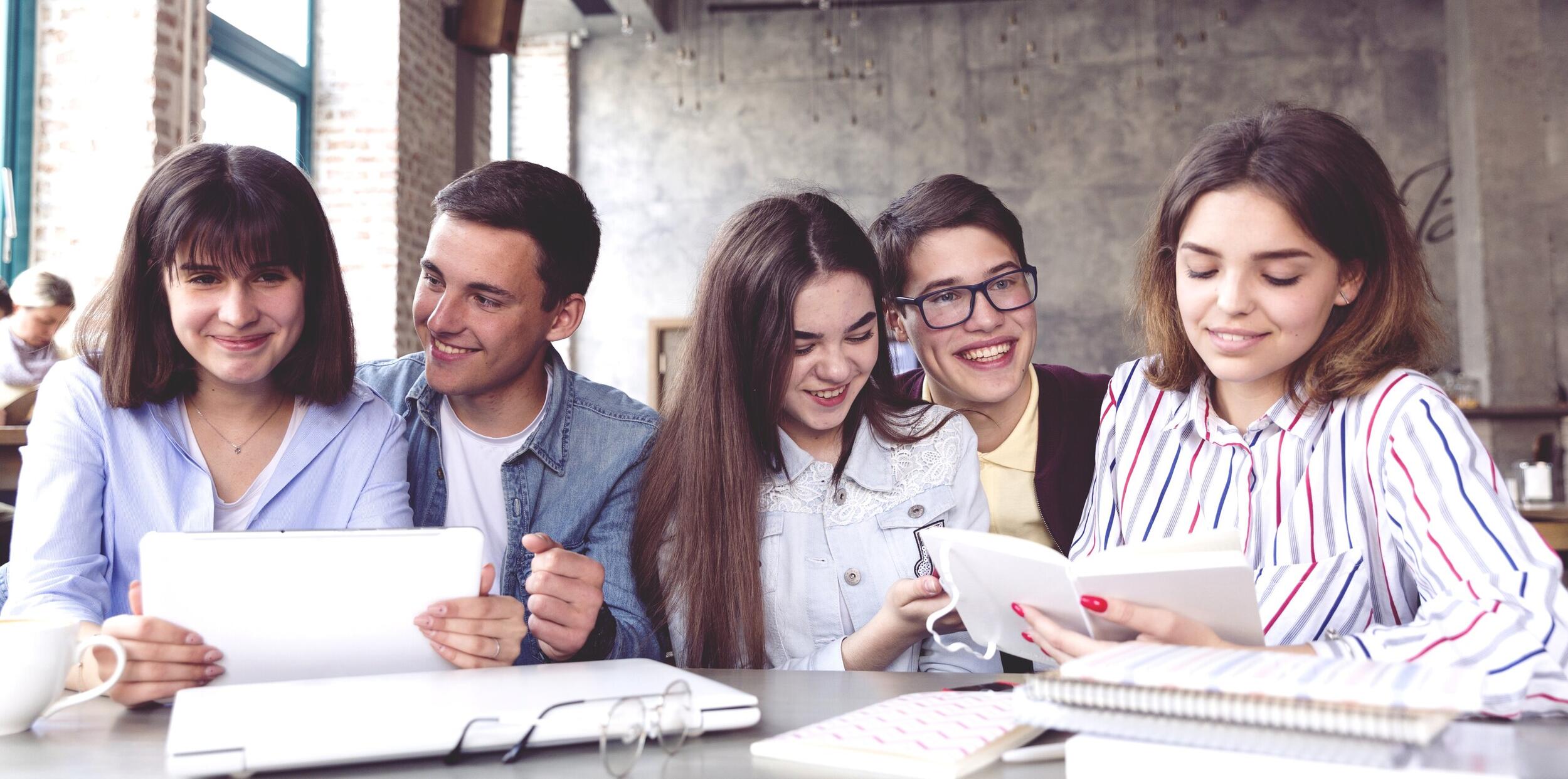 students-sitting-table-studying-with-books-tablet
